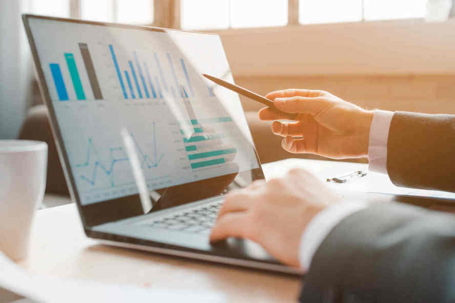 Ein zuverlässiger Partner Business-Mann zeigt auf Laptop mit Grafiken