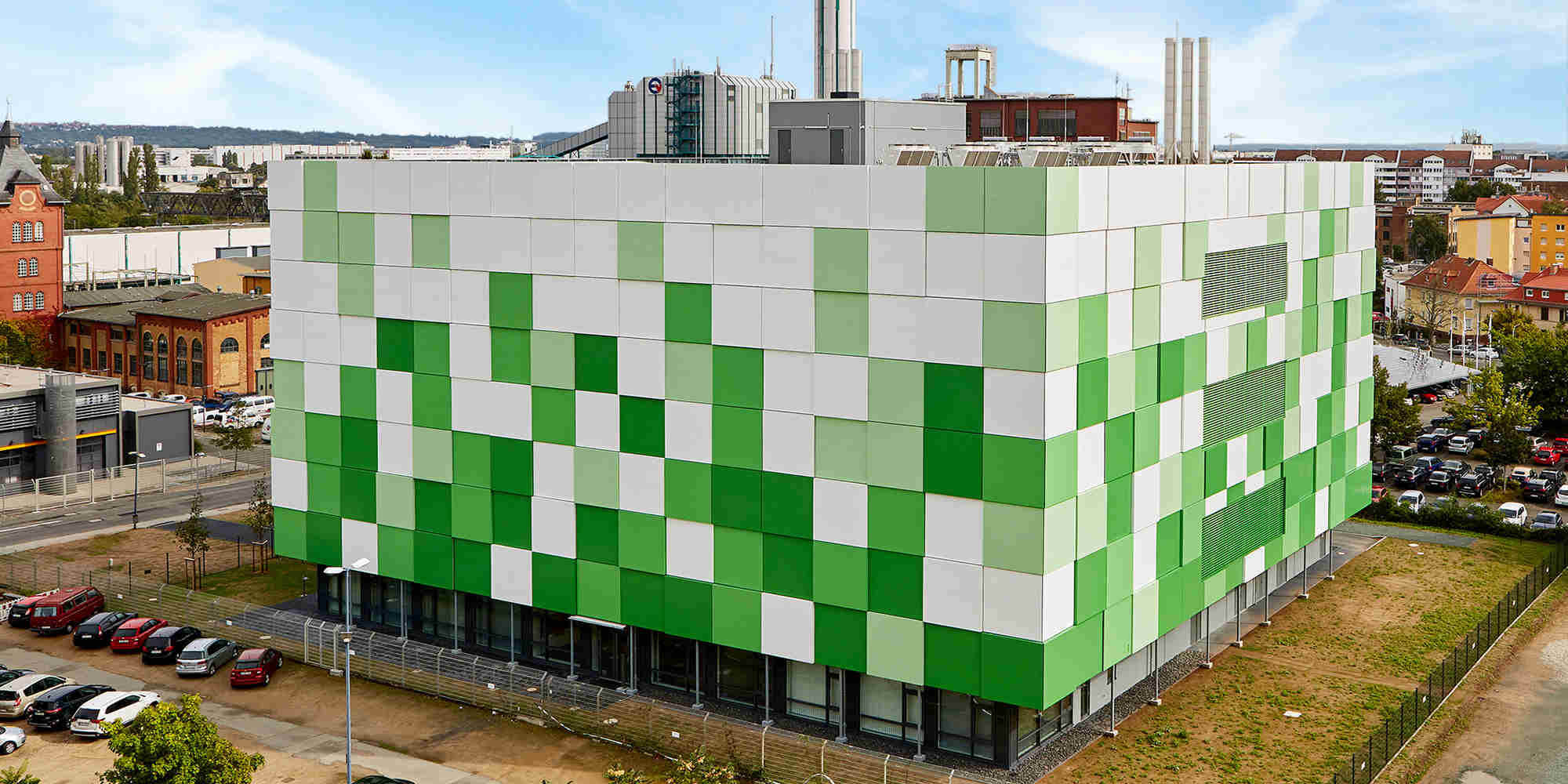 Unser Rechenzentrum im Herzen Frankfurts Ein grün/weißes Gebäude inmitten einer Stadt
